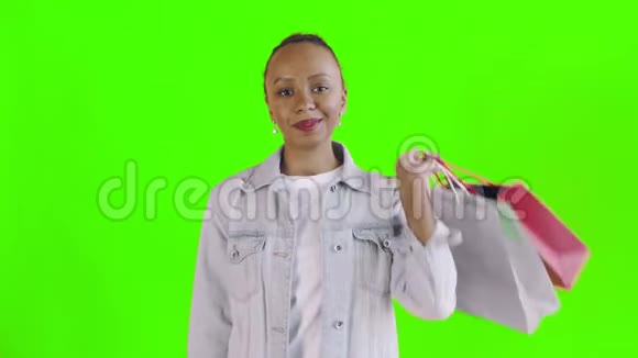美国黑人妇女的肖像与购物袋和金钱风扇在绿色背景在工作室琼夹夹克视频的预览图