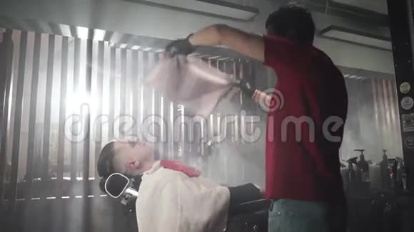 穿着红色T恤和黑色手套的理发师用毛巾围着客户视频的预览图