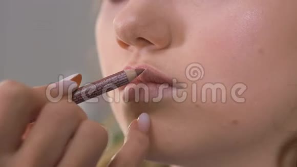 化妆师的作品用棕色校正铅笔敲击嘴唇轮廓视频的预览图