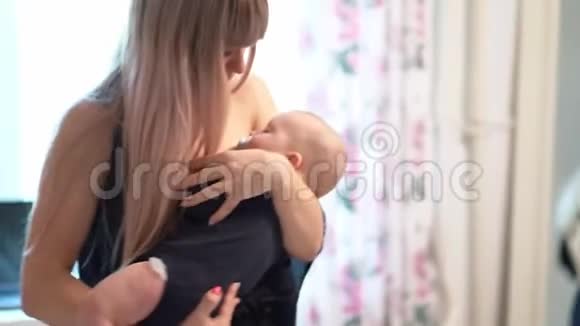 妈妈把熟睡的婴儿抱在家里的手里视频的预览图