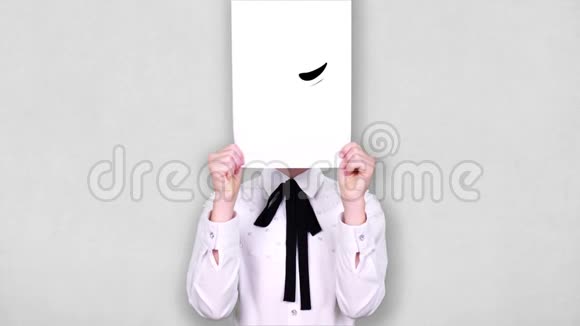 肖像少年手持白纸张用阴险鬼鬼祟祟的笑脸画动画遮脸情绪情绪视频的预览图