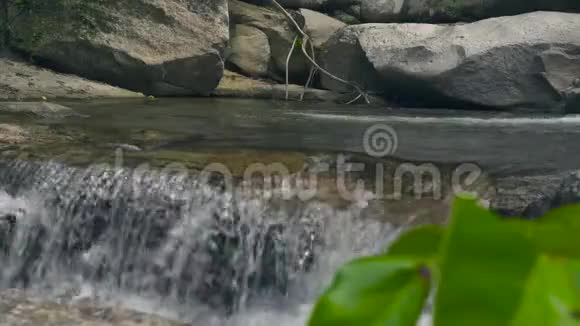 山河从瀑布上流淌在热带森林的大石头上瀑布瀑布瀑布中流淌的山河视频的预览图