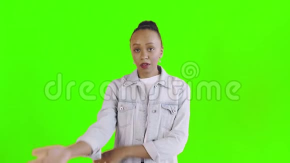 沮丧的非裔美国女孩在绿色背景下困惑地看着镜头的肖像面部表情视频的预览图