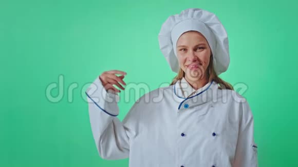 一个漂亮的女士面包师穿着制服戴着一个绿色的大背景色键概念用手指打字视频的预览图