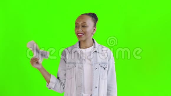 满意的非洲裔美国妇女的钱显示拇指在绿色背景让夹克视频的预览图