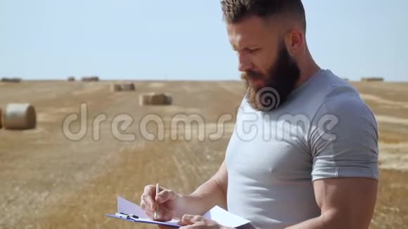蓄胡子的农夫手里拿着一块平板电脑手里拿着一封信写着干草捆视频的预览图