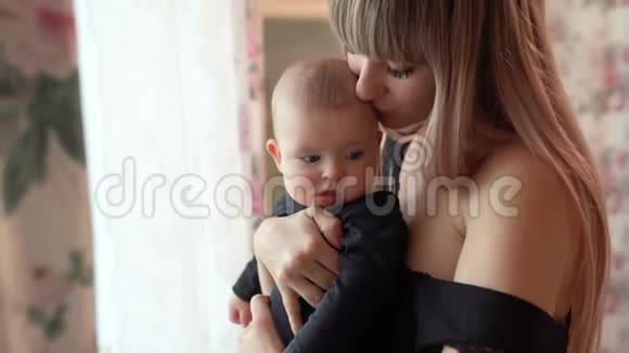 穿着黑衣服的母亲和孩子站在窗前视频的预览图