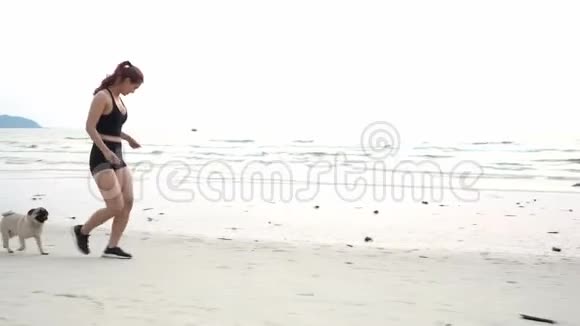强壮的女人在海滩上的沙滩上奔跑带着种视频的预览图