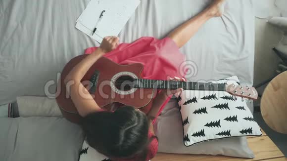 女人在床上弹声吉他视频的预览图