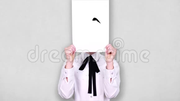 肖像少年手持白纸片用哭笑不得的图画动画遮脸情感想象视频的预览图
