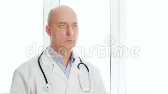 肖像医生穿着白色实验室外套在诊所办公室用听筒点头听诊器执业者视频的预览图