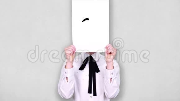 肖像少年手持白纸张带调皮的笑脸画动画遮脸情感想象视频的预览图