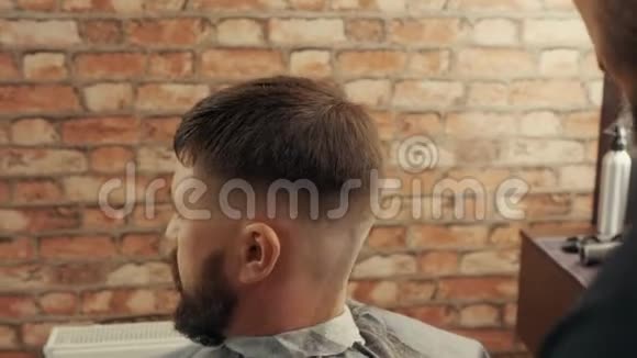 理发店理发师剪发给男性客户的特写镜头视频的预览图