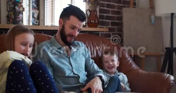 快乐年轻微笑的白种人父亲在家和小儿子和女儿玩家庭娱乐时间在一起慢动作视频的预览图