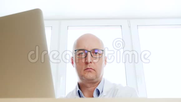 穿着医用长袍的男医生在诊所的桌子上给药男子药剂师在口袋前推药视频的预览图