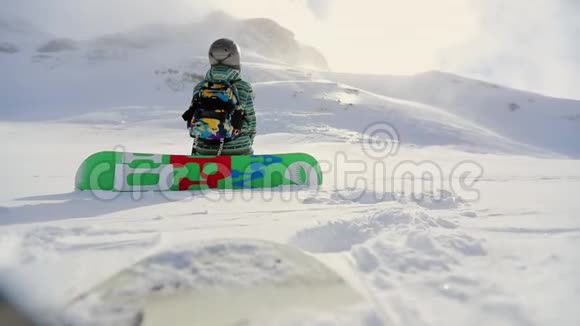 滑雪者坐在雪地里享受阳光和这项运动的美丽冬天在山上自由慢速视频视频的预览图