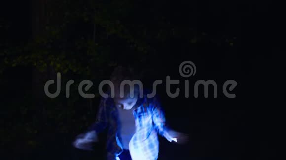 可爱的快乐男孩拿着手电筒晚上在森林里跳舞视频的预览图