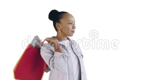 美国黑人妇女带着购物袋的肖像正在工作室的白色背景上喝咖啡琼夹夹克视频的预览图