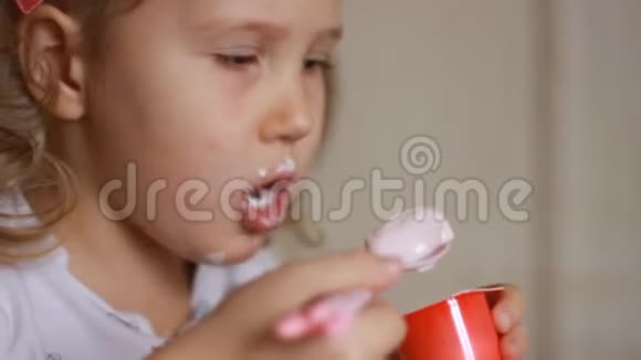 肖像特写小孩用勺子吃奶酪小女孩吃乳制品酸奶视频的预览图