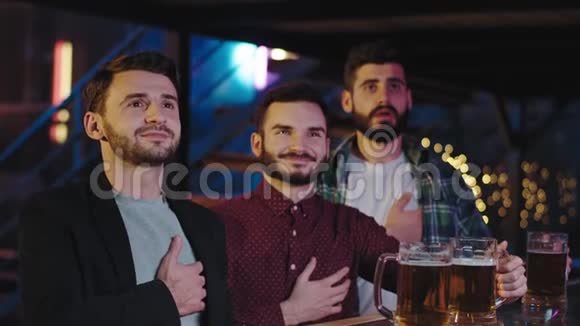 在一个有魅力的酒吧里朋友们微笑着快乐地享受着在酒吧桌上喝啤酒的时光视频的预览图