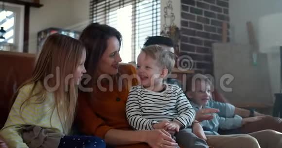 快乐的家庭时光在一起年轻的白种人妈妈爸爸和三个孩子在家看电影慢动作视频的预览图