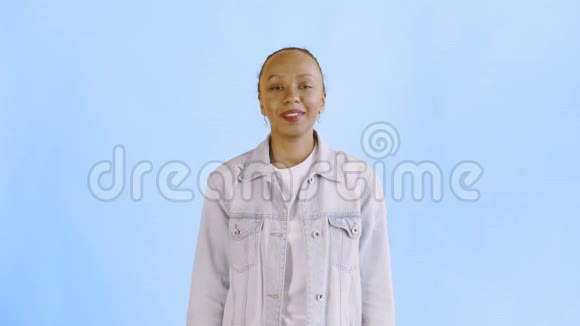 满意的兴奋的兴奋的非裔美国妇女在蓝色背景的让夹克上展示金钱说上帝的上帝视频的预览图