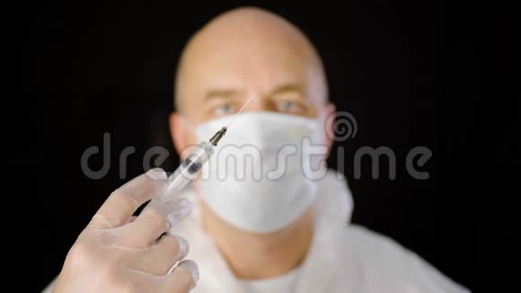 关闭医生手在保护手套持有注射器与注射隔离在黑色背景医务工作者视频的预览图