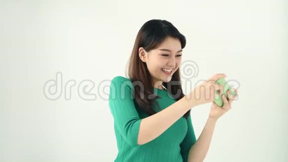 年轻的情绪化的女人站在灯光背景下一边打电话玩游戏视频的预览图