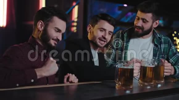 有魅力的好看的微笑的大个子在酒吧里喝着大杯啤酒他们一起享受时光视频的预览图