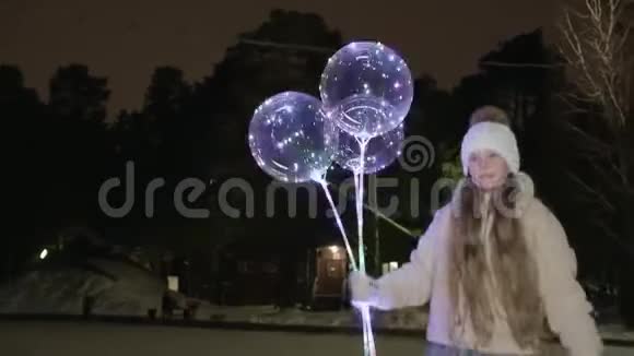 可爱的快乐女孩拿着发光的气球晚上滑冰视频的预览图
