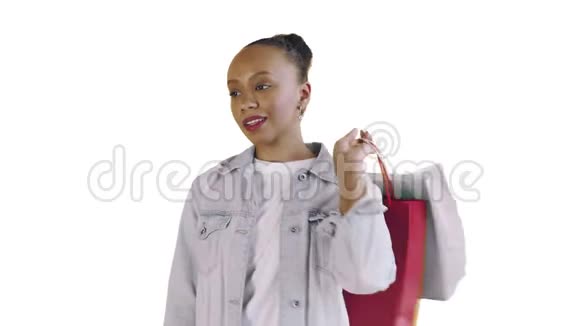 美国黑人妇女带着购物袋的肖像是在工作室的白色背景上通过智能手机谈论的让视频的预览图