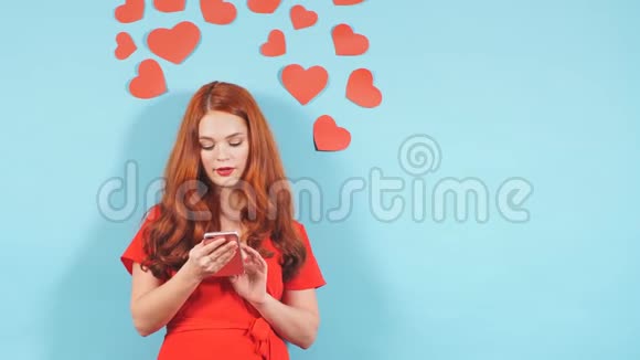 恋爱中的女人把手机隔在蓝色背景上视频的预览图