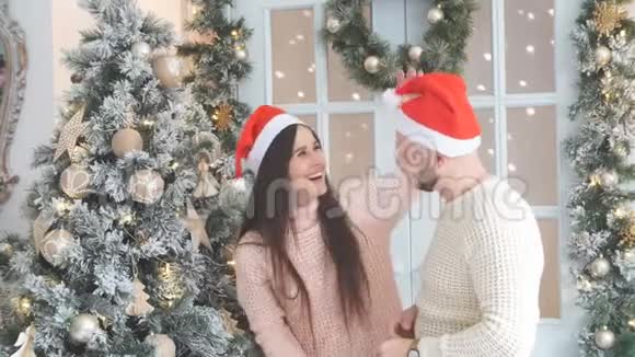 年轻夫妇在圣诞树附近玩得很开心视频的预览图