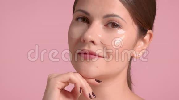 30岁的黑发女人穿着粉色背景的完美皮肤装饰上衣视频的预览图