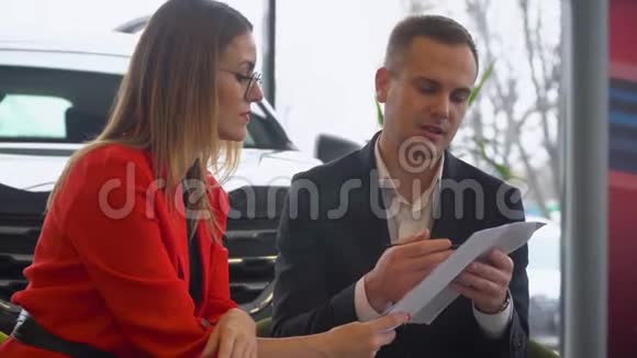卖方和买方正在研究汽车销售合同漂亮女人买车视频的预览图