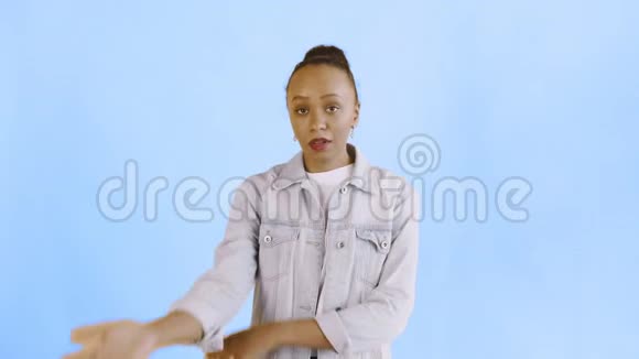 沮丧的非裔美国女孩在蓝色背景下困惑地看着镜头的肖像面部表情视频的预览图