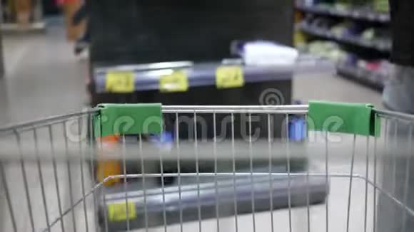 超市购物手推车运动超市里的时髦女人拿着购物车视频的预览图