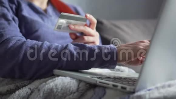 女性手使用笔记本电脑键盘输入信用卡信息视频的预览图