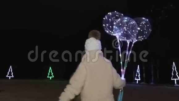 晚上儿童手持照明气球和滑冰的后景视频的预览图