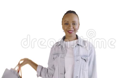 美国黑人妇女带着购物袋的肖像在工作室的白色背景上竖起大拇指琼夹夹克视频的预览图