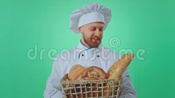 穿制服的面包师拿着一篮子新鲜面包他闻着面包的味道拍着视频视频的预览图