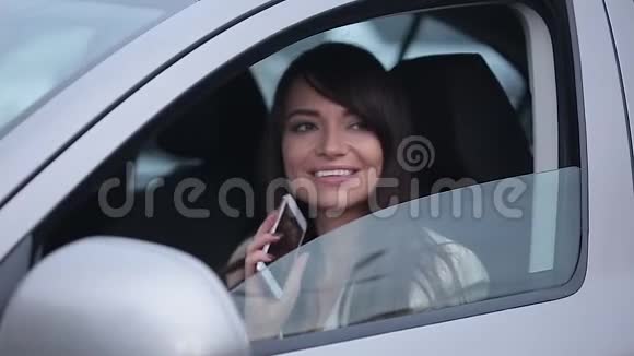 漂亮的商务女性坐在车里一边用手机说话一边微笑着视频的预览图