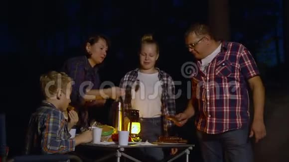 晚上露营时一家人吃烤香肠视频的预览图