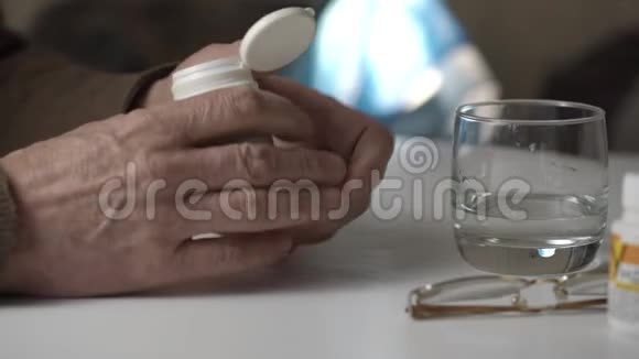 生病的老人在餐桌上用水吃药视频的预览图