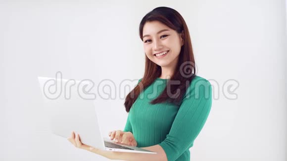 年轻的亚洲女性在笔记本电脑上工作在社交媒体上查看电脑背景很浅开心快乐开心快乐视频的预览图