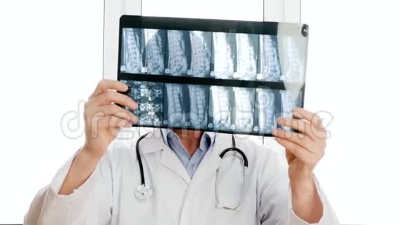 男医生看着X光的脊骨和负摇头肖像外科医生看着脊椎骨说不视频的预览图
