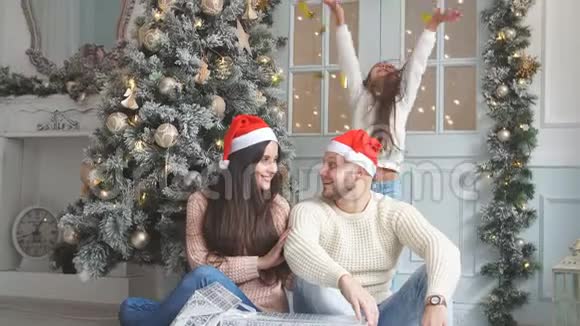 一个幸福的家庭围绕着一棵装饰好的圣诞树的圣诞照片视频的预览图