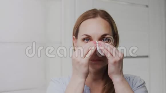 成年女性涂抹乳液看着镜头视频的预览图
