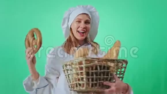 兴奋的面包师女人拿着一大篮子新鲜面包在镜头前跳舞她看着镜头使人发笑视频的预览图
