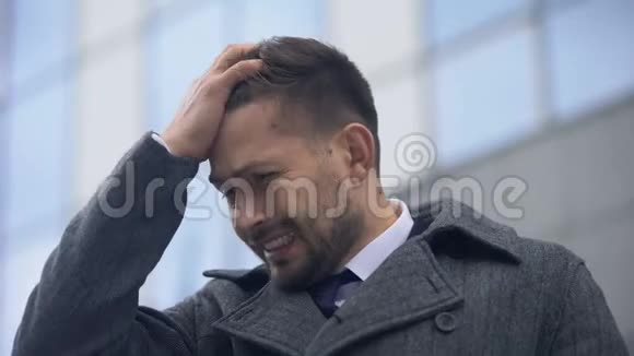 一个男人摸着头感觉剧烈的疼痛偏头痛天气变化视频的预览图